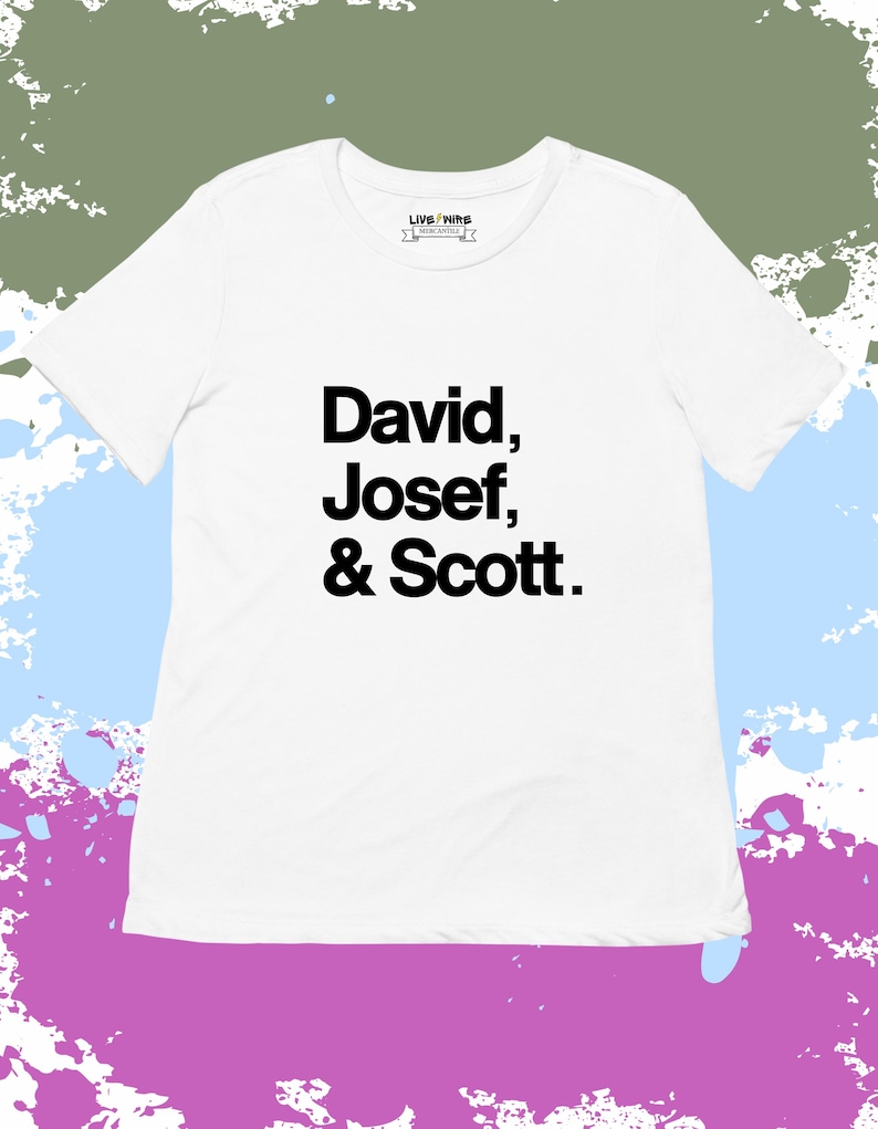 May include: White t-shirt with the names "David, Josef, & Scott" printed in black. The shirt has a crew neck and short sleeves. The brand logo "LIVE NIR" is printed on the upper chest.