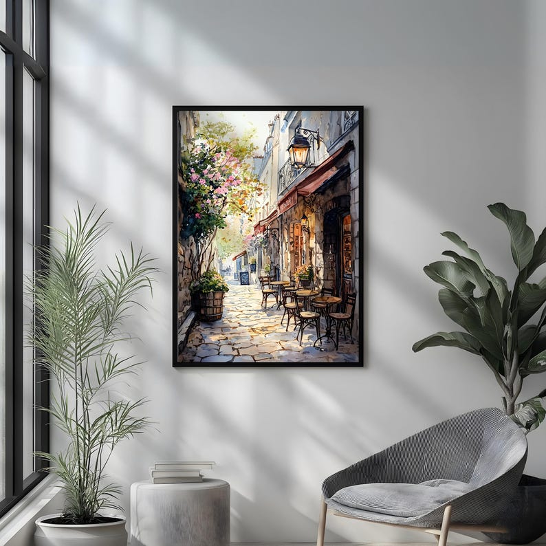May include: A watercolor painting of a Parisian street scene with a cafe on the corner. The cafe has a red awning and tables and chairs set up outside. There are trees and flowers in the background.