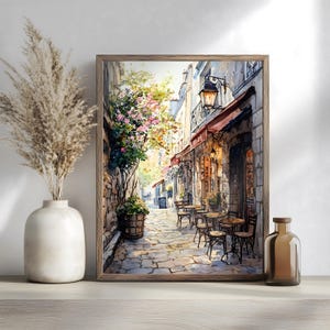 May include: A watercolor painting of a Parisian street scene with a cafe on the corner. The cafe has red awnings and a stone facade. There are tables and chairs set up outside the cafe, and people are sitting and enjoying the atmosphere. The street is cobblestone and lined with buildings. There are trees and flowers in the background.