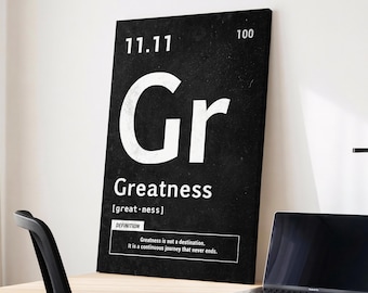 May include: A black and white rectangular canvas print with the word "Gr" in large white letters. Below, the word "Greatness" is written, along with a definition. The print is on a desk with a laptop and a black chair.