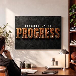 May include: A rectangular wall art piece featuring a black textured background with the white text PRESSURE MAKES and the large, three-dimensional, metallic copper-colored block letters spelling out the word PROGRESS.
