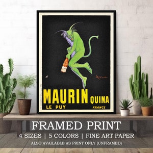 May include: Framed print of a vintage advertisement for Maurin Quina, a French tonic wine. The ad features a green, devil-like creature holding a bottle of the wine. The text on the ad reads "Maurin Quina, Le Puy, France".