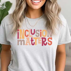 May include: A gray t-shirt with the text "inclusion matters" in colorful letters. The letters are in shades of orange, red, yellow, and brown.