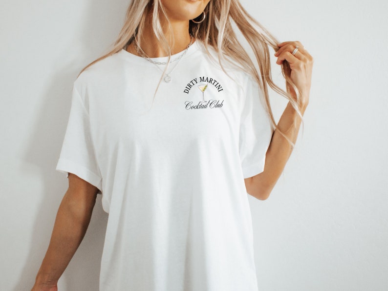 May include: White t-shirt with a black graphic that says "Dirty Martini Cocktail Club" and a martini glass illustration.