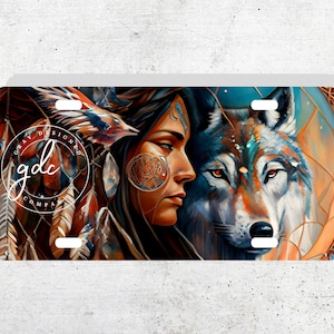 Puede incluir: Una pintura colorida de una mujer nativa americana con un lobo. La mujer tiene el pelo largo y negro y lleva un tocado con plumas. El lobo está mirando a la mujer con la cabeza inclinada. El fondo es una mezcla de colores azules, naranjas y marrones.