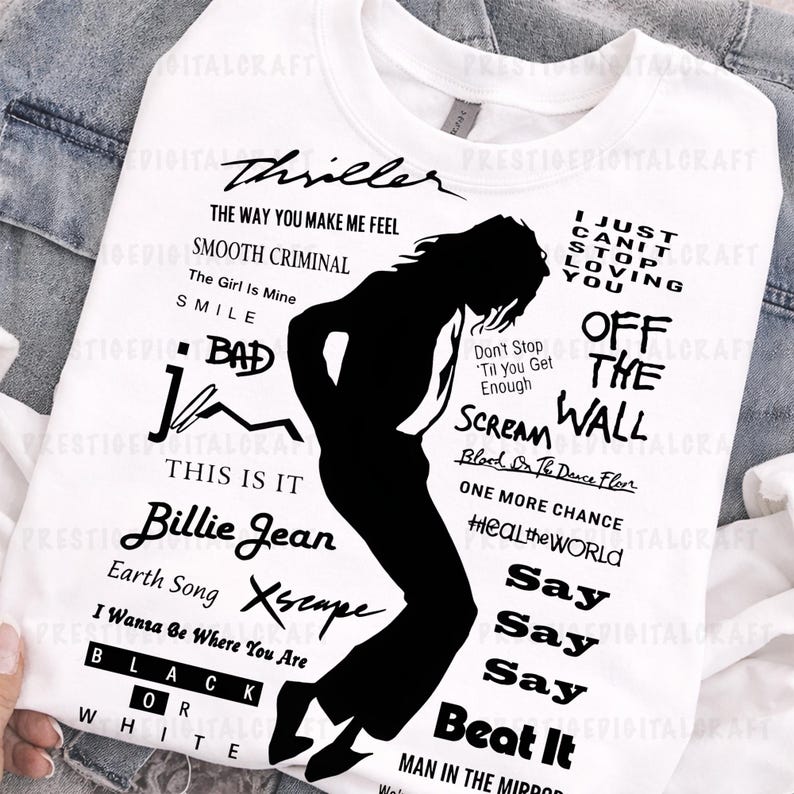 K&ouml;nnte beinhalten: Wei&szlig;es Sweatshirt mit einer schwarzen Silhouette eines T&auml;nzers und Songtiteln. Texte beinhalten "Thriller", "Billie Jean" und "Beat It". Das Sweatshirt befindet sich auf einem Jeans-Hintergrund.