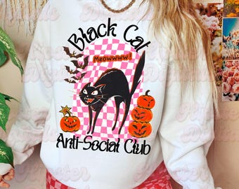May include: White sweatshirt with a Halloween-themed graphic. The design features a black cat, pumpkins, bats, and the text "Black Cat Anti-Social Club". The cat is arched with an angry expression, and the pumpkins are stacked.
