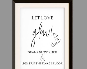 May include: A black and white sign with the text "LET LOVE glow!" and "GRAB A GLOW STICK & LIGHT UP THE DANCE FLOOR!" with three small hearts drawn in the top right corner.