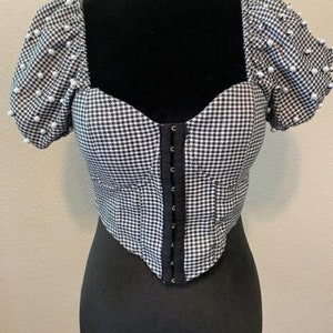 Crop Top. bustier bra, fitted, with puffy sleeves, embellished with pearls, houndstooth black and white fabric, hook and eye front opening.