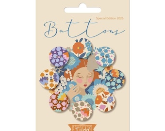 Könnte beinhalten: Eine Karte mit dekorativen Knöpfen mit floralen Mustern in verschiedenen Farben, darunter Blau, Orange und Lila. Das Wort "Buttons" ist in Schreibschrift geschrieben, und der Markenname "Tilda" ist ebenfalls sichtbar.