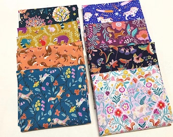 May include: A collection of folded fabric squares with various whimsical forest and floral patterns. Designs include foxes, rabbits, squirrels, and unicorns, in colors like teal, orange, and purple. Ideal for quilting or crafting projects.