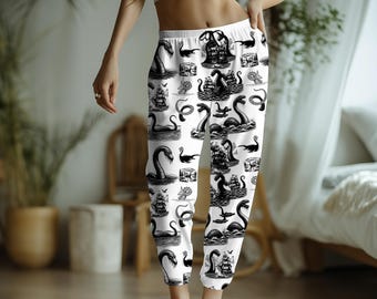May include: White sweatpants with a black and white print of a sea monster. The print is repeated all over the pants.