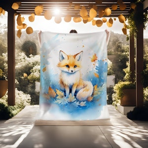 May include: A watercolor painting of a fox sitting on a bed of blue and yellow leaves. The fox is orange and white with a bushy tail.