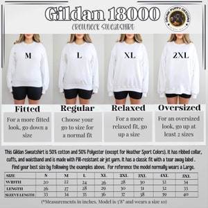May include: Size chart for Gildan 18000 crewneck sweatshirts. The chart shows the measurements in inches for different sizes, including width, length, and sleeve length. The chart also includes descriptions of the fit for each size: fitted, regular, relaxed, and oversized.