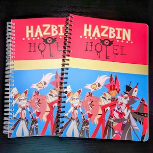 May include: A spiral bound notebook with a red, yellow, and blue cover featuring the text "Hazbin Hotel" and cartoon characters.