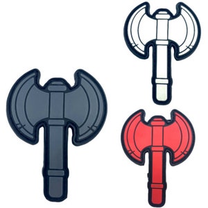 May include: Three double-headed axe patches in different colours: black, white and red. The patches are made of rubber and have a detailed design.