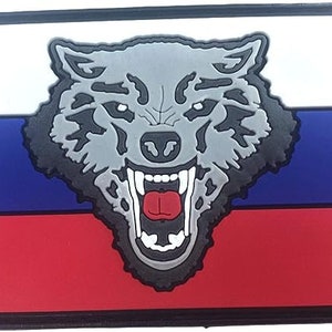 Könnte beinhalten: Rechteckiger Aufnäher mit der russischen Flagge und einem grauen Wolfskopf-Emblem. Die Flagge ist in horizontale Streifen in Weiß, Blau und Rot unterteilt. Der Wolfskopf hat schwarze Umrisse und eine rote Zunge.