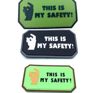 Peut inclure: Trois versions différentes d'un patch vert, noir et vert clair avec un geste de la main et le texte "THIS IS MY SAFETY!"