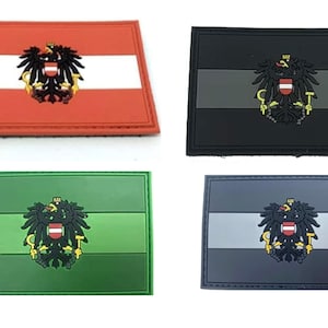 May include: Four embroidered patches featuring the Austrian flag with the Austrian coat of arms. The patches are in red, black, green, and grey.