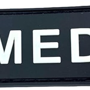 May include: Black patch with white text that reads "MEDIC" and a German flag in the top left corner.