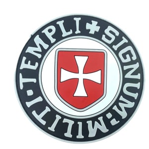 Peut inclure: Un écusson rond noir et argent avec le texte "MILIT-TEMPLI+SIGNUM" autour du bord. Au centre se trouve une croix blanche sur un bouclier rouge.