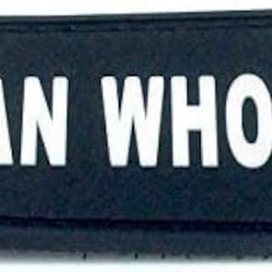 May include: Black patch with white text that reads "MAN WHORE".