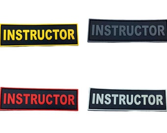May include: Four black rectangular patches with the word "INSTRUCTOR" in white, yellow, red, and grey lettering.