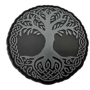 Könnte beinhalten: Ein gestickter schwarzer und silberner Aufnäher mit einem Lebensbaum-Design und komplizierten Knotenarbeiten an den Rändern.