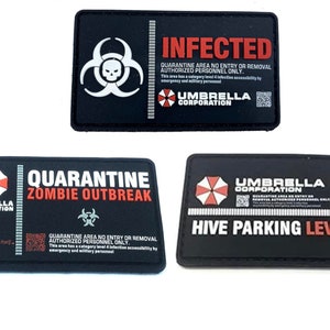 Può includere: Tre toppe ricamate nere e rosse con il logo di Umbrella Corporation e il testo "Quarantine Zombie Outbreak", "Infected Quarantine Area No Entry or Removal Authorized Personnel Only" e "Hive Parking Level 3".