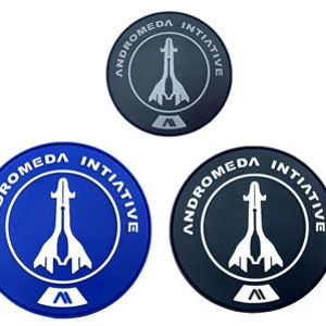 Peut inclure: Trois patchs ronds avec le logo d'Andromeda Initiative. Le logo représente un vaisseau spatial blanc avec les mots "Andromeda Initiative" en cercle autour de lui. Les patchs sont disponibles en trois couleurs : noir, bleu et gris.