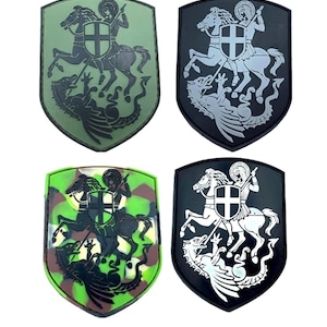 May include: Four embroidered patches featuring a knight on horseback slaying a dragon. The patches are in four different colour schemes: green camouflage, black with silver embroidery, green and brown camouflage, and black with white embroidery.