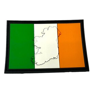 May include: A green, white and orange Irish flag patch with a white outline of the island of Ireland in the centre. The patch is surrounded by a black border.