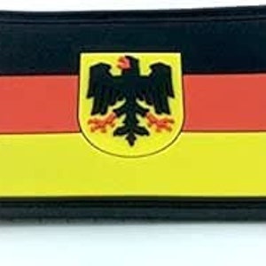 May include: A black, yellow and red German flag patch with the German eagle emblem in the centre. The patch is made of rubber and has a black border.