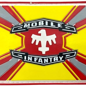 Pode incluir: Um remendo vermelho, amarelo e cinza com uma águia branca e o texto "MOBILE INFANTRY".