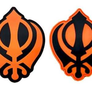 Può includere: Due toppe ricamate arancioni e nere che rappresentano il simbolo sikh, il Khanda. Il Khanda è un simbolo di fede, potere e sovranità.