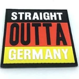 Op de afbeelding: Een rechthoekige patch met de tekst "STRAIGHT OUTTA GERMANY". De patch heeft een zwarte rand, een rode en gele streep en witte letters. De patch is waarschijnlijk gemaakt van stof of een vergelijkbaar materiaal.
