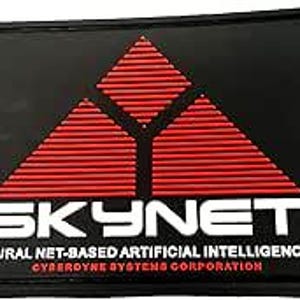 Może przedstawiać: Czarno-czerwona łatka z geometrycznym logo w kształcie trójkąta i napisem "SKYNET" w kolorze białym. Pod logo znajduje się napis "NEURAL NET-BASED ARTIFICIAL INTELLIGENCE" i "CYBERDYNE SYSTEMS CORPORATION" w kolorze białym.