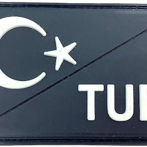 May include: A black patch with a white crescent moon and star, and the word "TUR" in white letters.