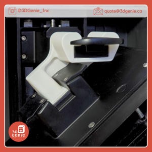 May include: A close-up of a 3D-printed white and black component. The white part has a curved design with a black handle. The component is attached to a black surface with screws. The image includes the text "@3DGenie_Inc" and "quote@3dgenie.ca".