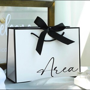 May include: A handmade wooden sign with the text "Welcome" in a playful font. The sign is painted white with a distressed finish, and features a decorative floral design in shades of pink and green. It measures approximately 12 inches wide.