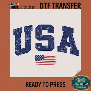 May include: A white DTF transfer with the word "USA" in distressed blue lettering and a distressed American flag graphic. The words "READY TO PRESS" are at the bottom.