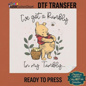 May include: DTF transfer featuring Winnie the Pooh with the text "I've got a Rumbly in my Tumbly." The design includes a honey pot, bees, and a ladybug. The words "READY TO PRESS" are also included.