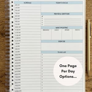 May include: A spiral-bound daily planner page with a schedule from 6:00 AM to 10:00 PM, sections for Today's Focus, Prayer & Gratitude, What I'm Eating, Exercise, and a To-Do List. A gold pen sits to the right. Text reads: One Page Per Day Options...