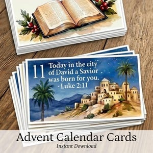 May include: A stack of rectangular cards featuring watercolor illustrations. One card shows an open book with red berries, while another displays a night scene with a desert town, palm trees, and the text: 11 Today in the city of David a Savior was born for you. Luke 2:11.