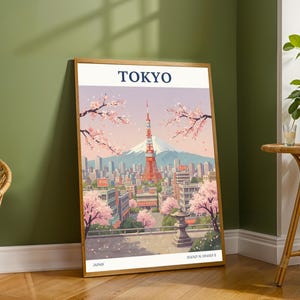 Può includere: Una stampa artistica incorniciata con un'illustrazione stilizzata di Tokyo, Giappone. L'immagine mostra la Tokyo Tower, il Monte Fuji e fiori di ciliegio. La parola "TOKYO" è stampata in alto, "JAPAN" in basso.