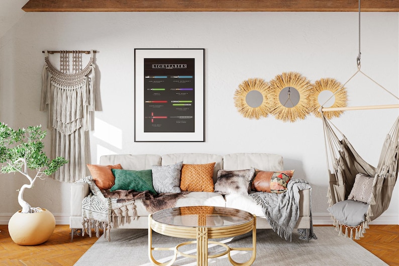 May include: A living room interior featuring a cream sofa with cushions, a round coffee table, and a framed poster displaying the word "Lightsabers". The wall also has three sunburst mirrors and a hanging chair.