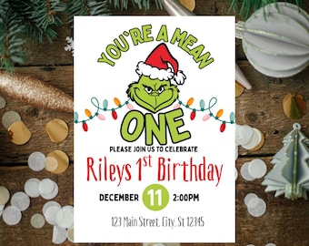 May include: A birthday invitation featuring the Grinch wearing a Santa hat. The text reads "You're a Mean One" above the Grinch, with "ONE" in large letters. The invitation is for Riley's 1st Birthday on December 11th at 2:00 PM.