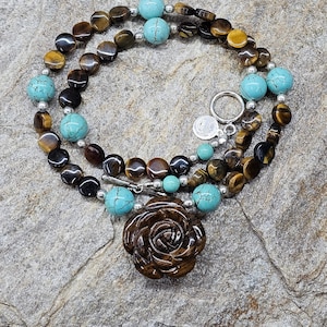 Southwest beaded necklace! Carved tiger&#39;s eye floral focal bead, tiger&#39;s eye disc, round turquoise colored howlite, sterling silver.