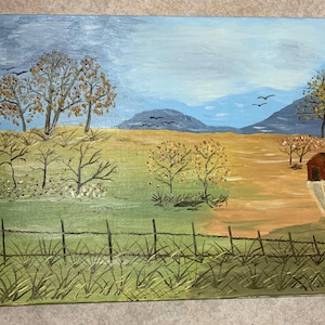 May include: Acrylic painting of a rural landscape with a fence in the foreground. The painting features a field with trees, a red barn, and mountains in the background. The sky is blue with some clouds, and birds are flying overhead.