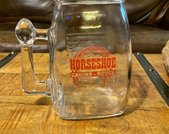 Jarra de cerveza vintage de cristal del Casino Horseshoe en Bossier City, LA, con logotipo en letras rojas. Ideal para juegos de azar, souvenirs, coleccionables, máquinas tragamonedas y regalos. Bin M